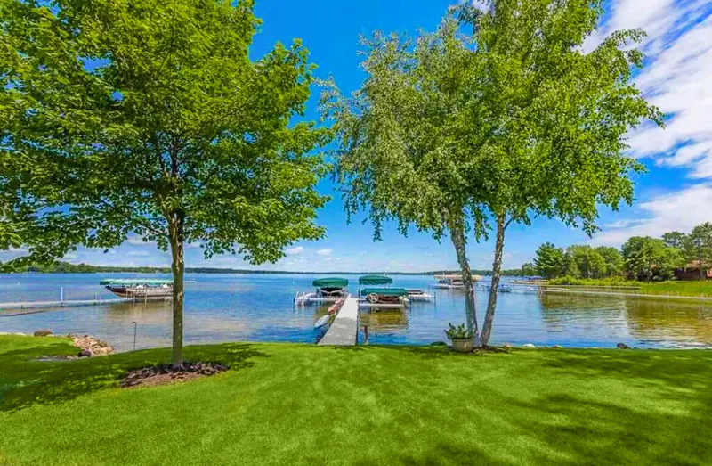 Lawn running down to the water and a dock on the Whitefish Chain