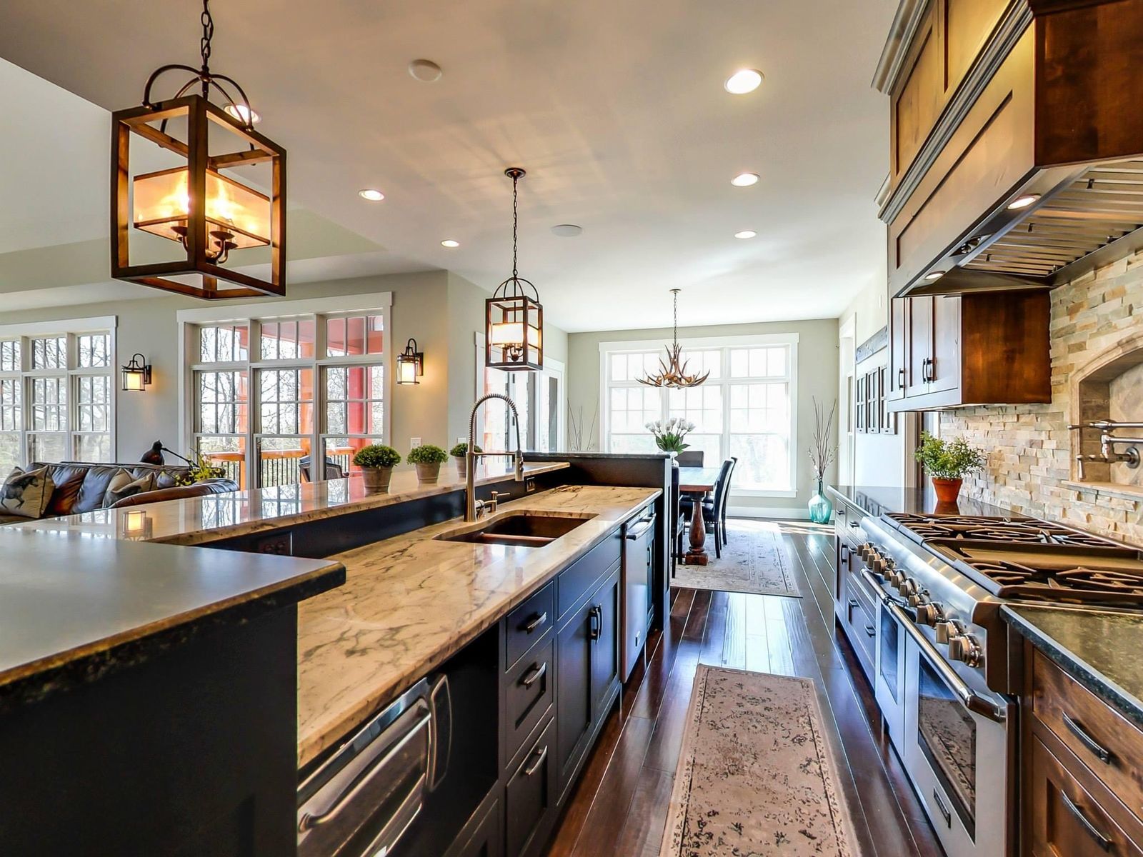 Chef’s kitchen with a long island, stone backsplash and lantern pendants, an Ivy Lane Homes interior